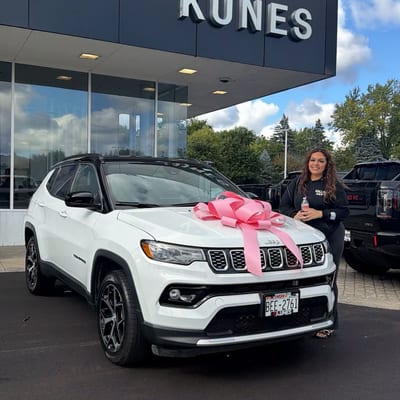 Customer posing with her new car and pink bow
